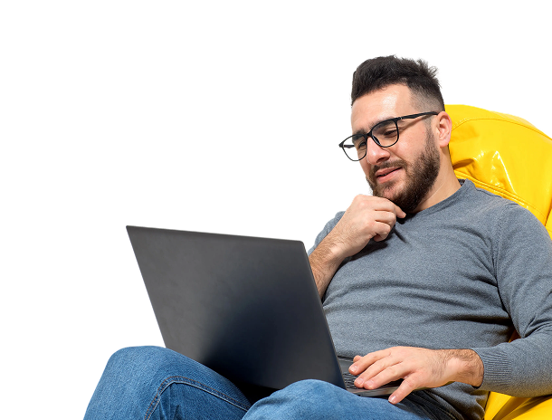 Man working on a laptop while seated in a yellow chair