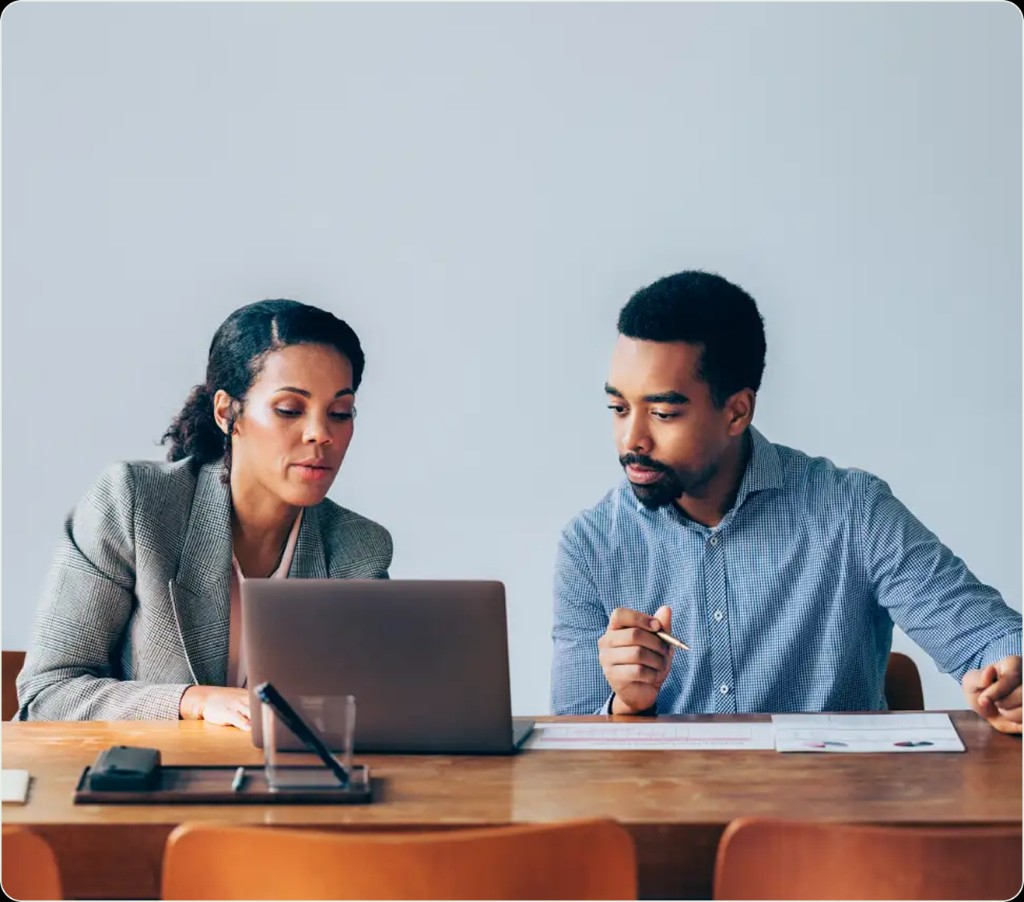 Marketing teammates reviewing work together on a laptop